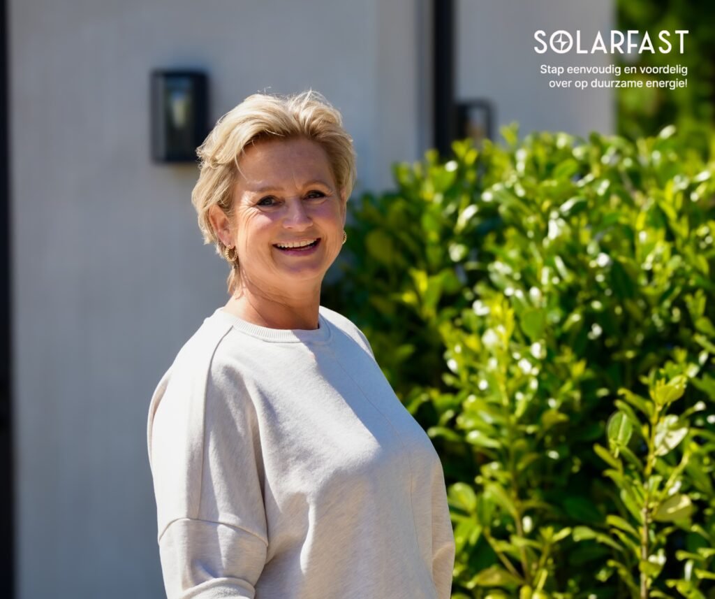 Klant van zonne-energiebedrijf in Amstelveen lacht na installatie van zonnepanelen, foto voor website